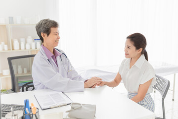 Obraz premium asian female doctor holding hand of patient in mental health clinic, patient have a problem health in hospital, hand in hand, healthcare promotion