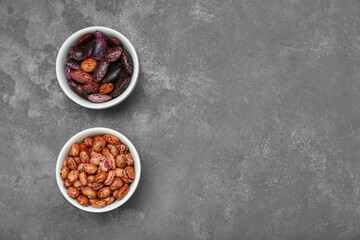 Bowls with different types of beans on grey table, flat lay. Space for text