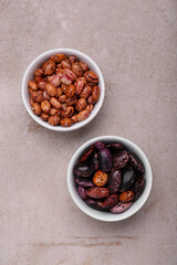 Bowls with different types of beans on light grey table, flat lay