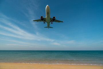 Fototapeta na wymiar Airplane will landing near blue beach