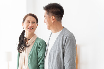 リビングにいる笑顔で話す高齢者夫婦