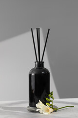 Black glass diffuser with the scent of flowers. The concept of home comfort, perfumes for the room.