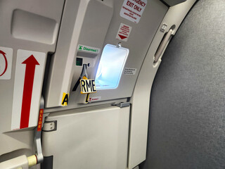 Airplane exit hatch with warning signs, unarmed