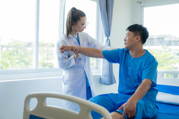 Female doctor's hand doing physiotherapy stretching the shoulder of a male patient. Doctor or physiotherapist working on male patient's limb muscle injury in clinic