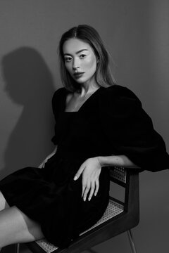 Woman in black long sleeve dress sitting on chair