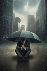 businessman with umbrella kneeling in the rain
