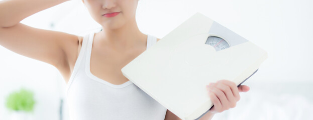 Portrait beautiful young asian woman holding scales with upset and displeased of control dieting, beauty girl stress and frustrated, emotion and expression, weight loss, health and problem concepts.