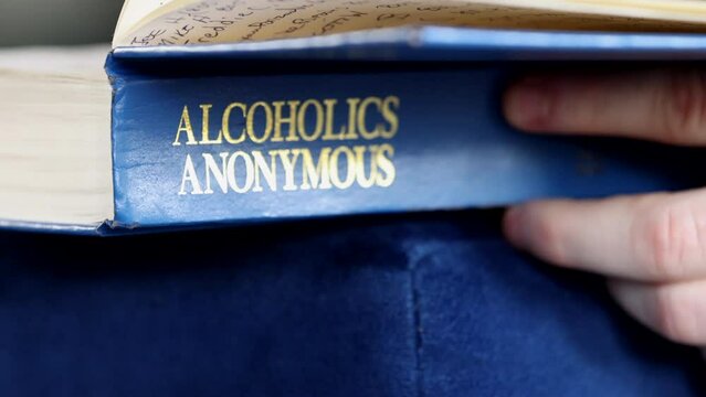 Hands holding an opening alcoholic anonymous book. High quality 4K footage. Los Angeles California