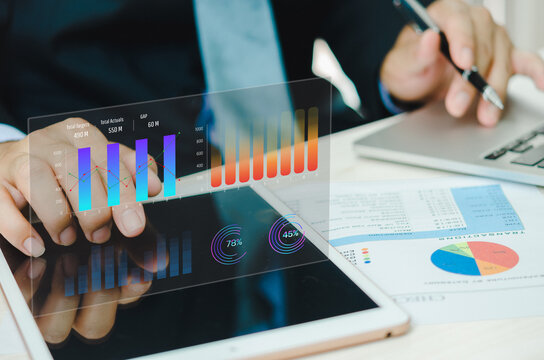 Businessman using tablet with statistics, graph and chart virtual hologram of statistics.Data analytics and statistics. business marketing investment and financial concept.