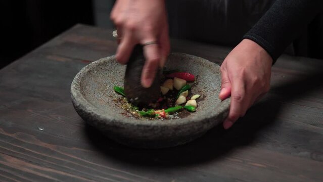 Close up the chef is pounding chili sauce. Sambal is a famous food from Indonesia