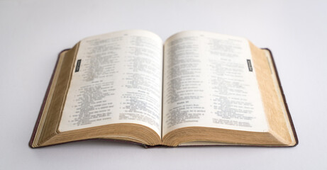 Holy Bible open in the centre. On white background.