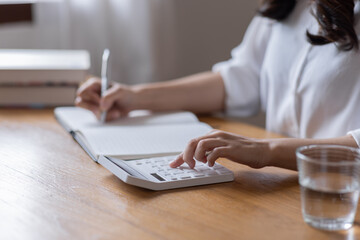 Closeup hands of businessman working on desk office with using a calculator to calculate the numbers, finance accounting concept
