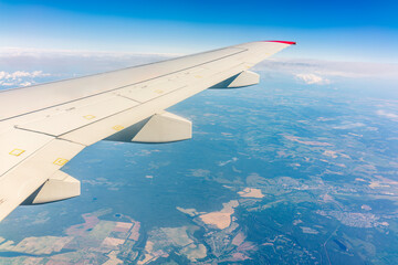 View from the airplane window at a beautiful cloudy sky and the airplane wing