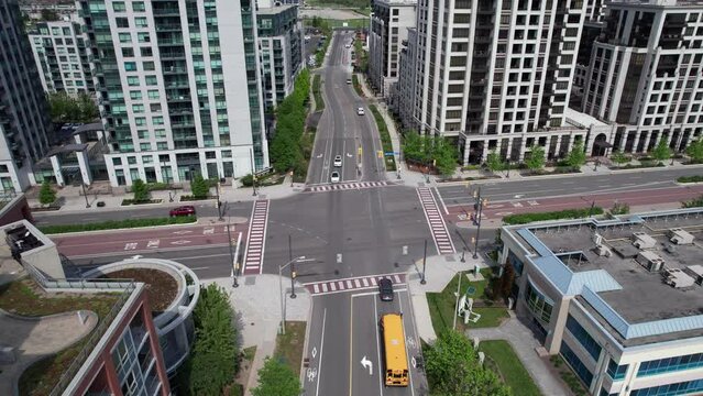 City of Markham intersection upward pan revealing condos and car traffic with school bus at stoplight at Clegg Road and South Town Centre Boulevard