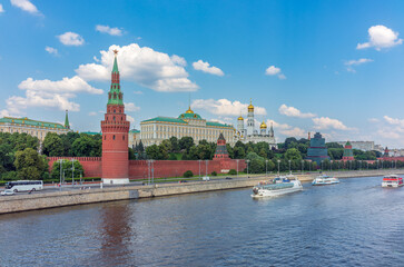 Obraz premium View of Kremlin with Vodovzvodnaya tower, Grand Kremlin Palace from repaired Bolshoy Kamenny Bridge in Moscow city on sunny summer day. Cruise ship sails on the Moscow river