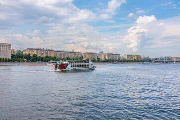 Naklejka premium Cruise ship sails on the Moscow river in Moscow city center, popular place for walking.
