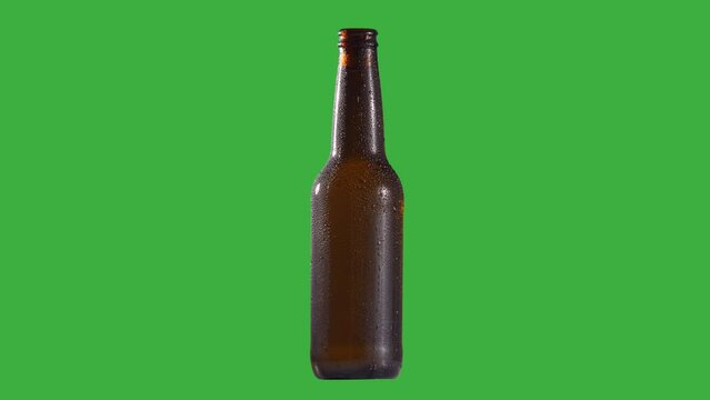 Spinning beer bottle ambar glossy wet humid drops detail for background replacement green background chroma key