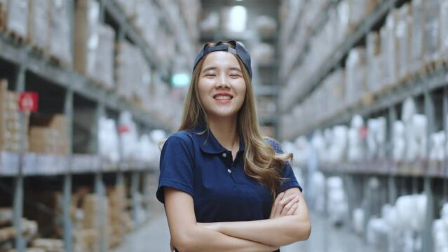 Portrait of Asian female smiling while standing in warehouse factory. 