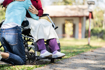 Obraz premium Nursing home. Young caregiver helping senior woman in wheelchair.