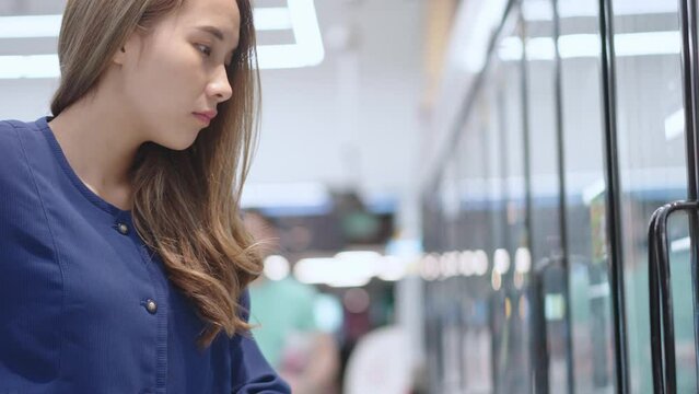 Asian woman shopping at Supermaket store buy choose dairy products.