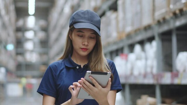 Asian female using tablet checking amount of stock product inventory on shelf at distribution warehouse factory. logistic business shipping and delivery logistic service.