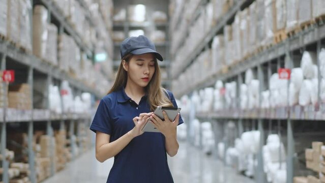 Asian female using tablet checking amount of stock product inventory on shelf at distribution warehouse factory. logistic business shipping and delivery logistic service.