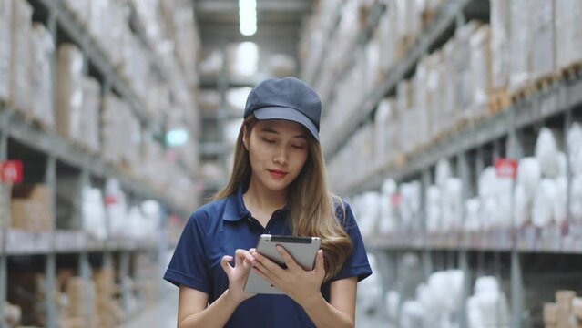 Asian female using tablet checking amount of stock product inventory on shelf at distribution warehouse factory. logistic business shipping and delivery logistic service.