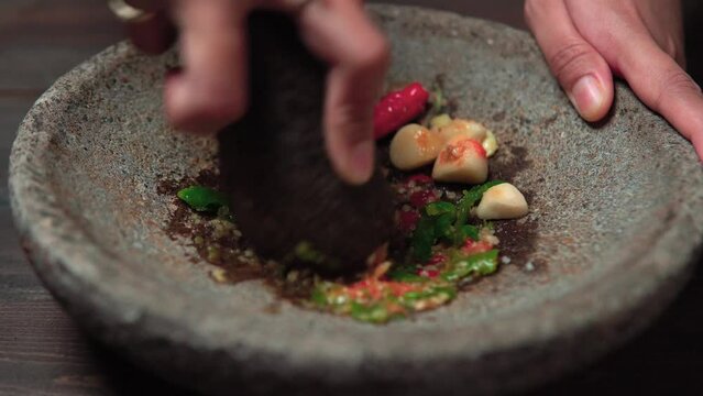 Close up the chef is pounding chili sauce. Sambal is a famous food from Indonesia