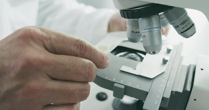 Hand, slide and microscope blood sample in lab with virus research for healthcare innovation. Medical, science and laboratory study at hospital and clinic for pathology investigation for DNA disease