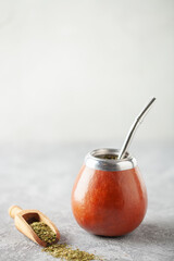 Healthy infused drink, classic Yerba Mate tea in calabash with bombilla on grey background