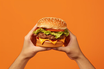 Hands holding a hamburger isolated on orange background. Created with Generative AI Technology