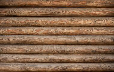 Background of a wooden wall of a house made of a round beam.