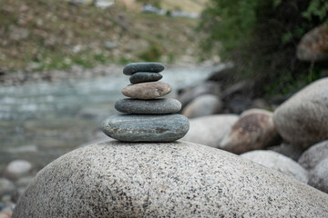 Fototapeta na wymiar Rocks stack on the coast of summer Mountain River, concept of balance and harmony.