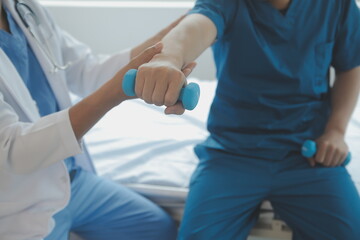 Obraz premium Doctor or Physiotherapist working examining treating injured arm of athlete male patient, stretching and exercise, Doing the Rehabilitation therapy pain in clinic.