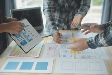 Close up ux developer and ui designer brainstorming about mobile app interface wireframe design on...