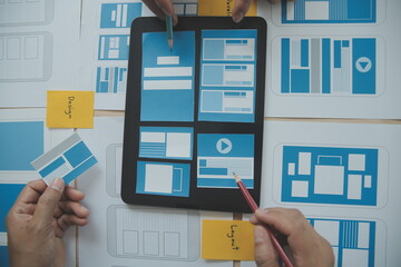 Close up ux developer and ui designer brainstorming about mobile app interface wireframe design on...