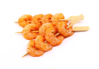 Skewers of spicy shrimp on a white background.