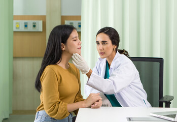 Fototapeta premium Young asian woman consulting about cosmetic surgeon on face for beauty procedures. Atmosphere at cosmetic surgery department in hospital clinic.