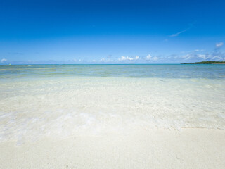 Fototapeta na wymiar 晴れた日の沖縄県読谷村の宇座海岸の白い砂のビーチと波打ち際