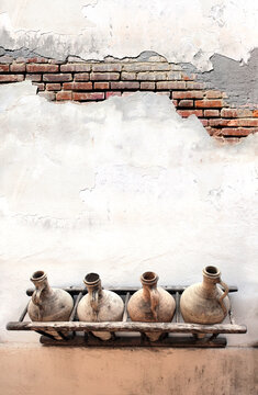 Vertical banner with Old pitchers on white stucco wall. Vintage clay wine jars on concrete wall. Traditional mediterranean wall decoration of a village house. Mock up template. Copy space for text