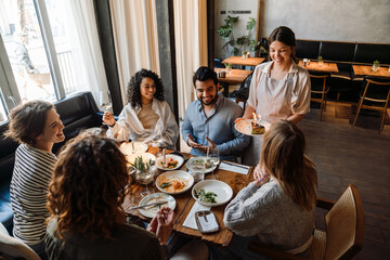 Group of friends celebrating birthday in restaurant