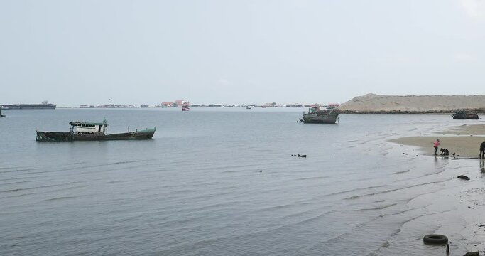 Abandoned fishing boats off the coast of Sihanoukville. Some people looking for crabs or shellfish at low tide 