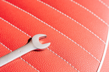 a wrench on the leather seat of a motorcycle during repair