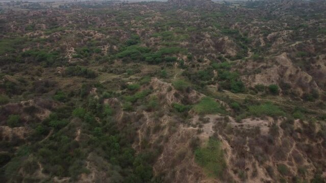 Aerial pullback shot of unique gully erosions of the iconic badlands of Chambal ravines next to the national highway in Morena Rajasthan Madhya Pradesh, India
