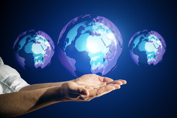 Close up of male hand holding glowing digital globe hologram on dark background. Digital world,...
