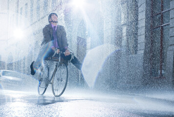 Businessman riding bicycle in rainy street