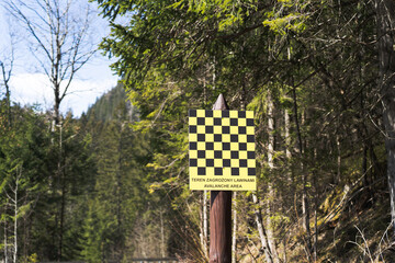 Danger - Avalanche area warning sign in Tatra mountains. Avalanche area warning sign in english and polish language, valley in Tatra mountains, Spring time