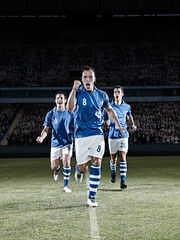 Soccer players running on field © KOTO