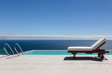 Infinity pool and lounge chair overlooking ocean