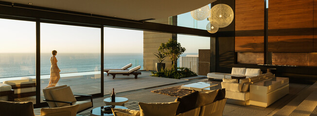 Woman walking on modern patio overlooking ocean